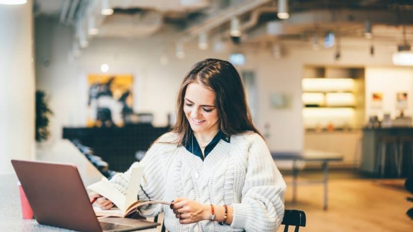 Businesswoman working on laptop in modern coworking.