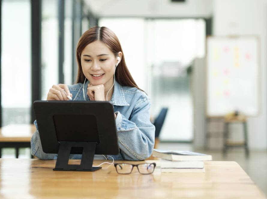 Young female student learning online using tablet.