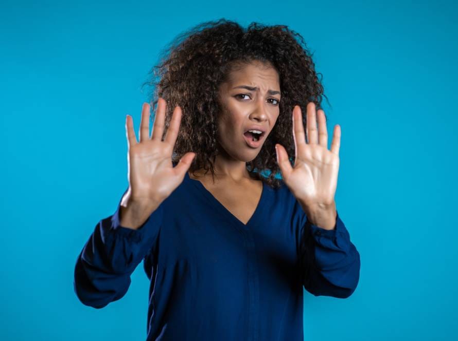 Angry annoyed woman raising hands up to say no stop