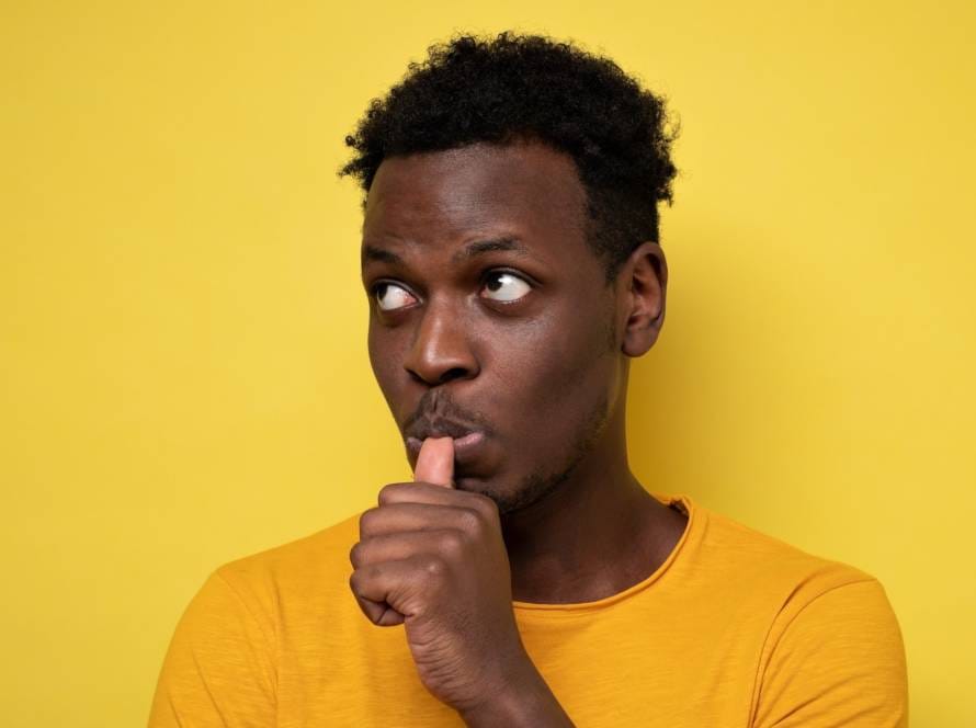 Man with finger in mouth sucking thumb or biting fingernail in stress